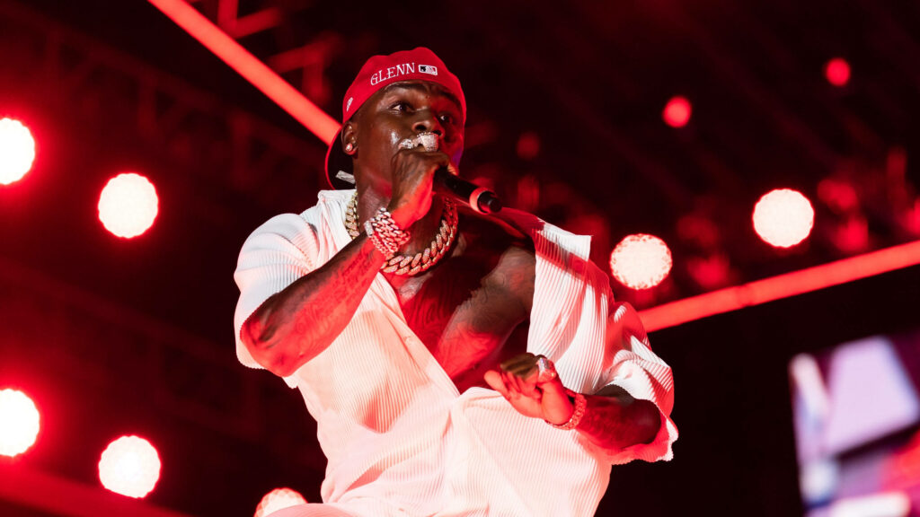 DaBaby performing live at Lollapalooza with red lighting open shirt and signature red cap wallpaper