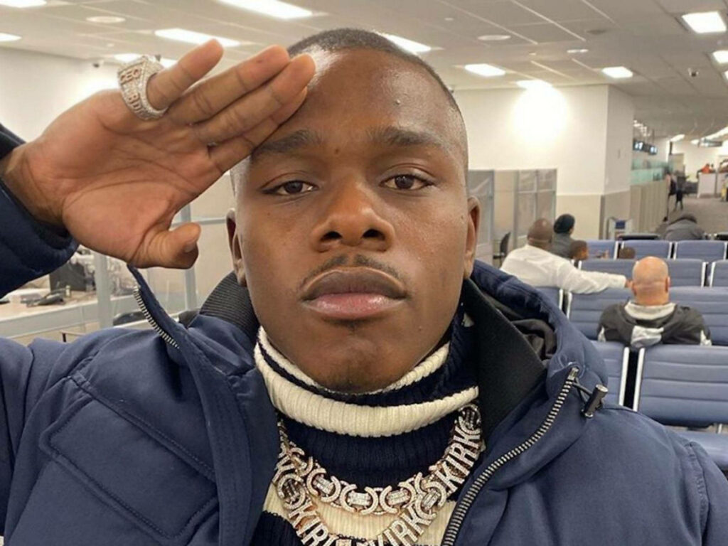 DaBaby rapper close-up saluting at airport wearing navy jacket and statement jewelry wallpaper