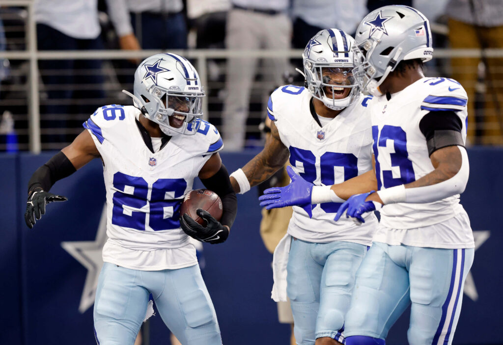 DaRon Bland 26 celebrating with Dallas Cowboys teammates in vibrant white and blue uniforms wallpaper