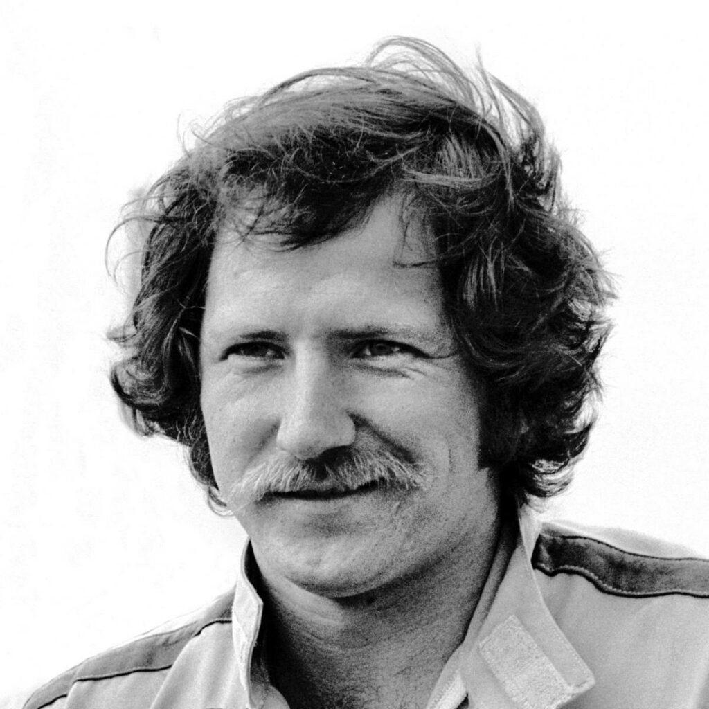 Black and white wallpaper of NASCAR legend Dale Earnhardt with confident gaze and mustache