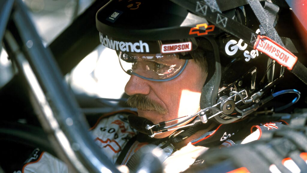 Dale Earnhardt focused in race car close-up with helmet mustache and detailed NASCAR gear wallpaper