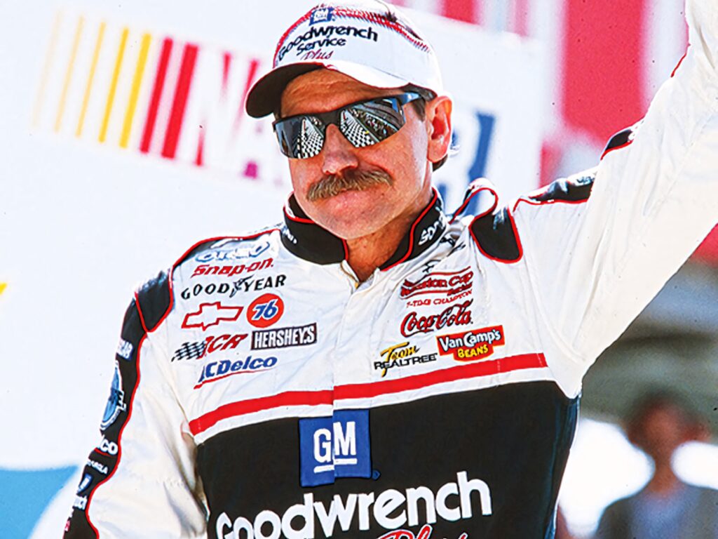 Dale Earnhardt NASCAR driver in iconic racing suit with reflective sunglasses on vibrant track Wallpaper