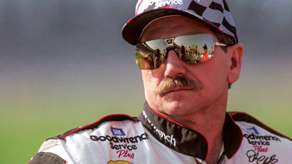 Dale Earnhardt in classic NASCAR suit sunglasses with Goodwrench logo and racing reflection wallpaper