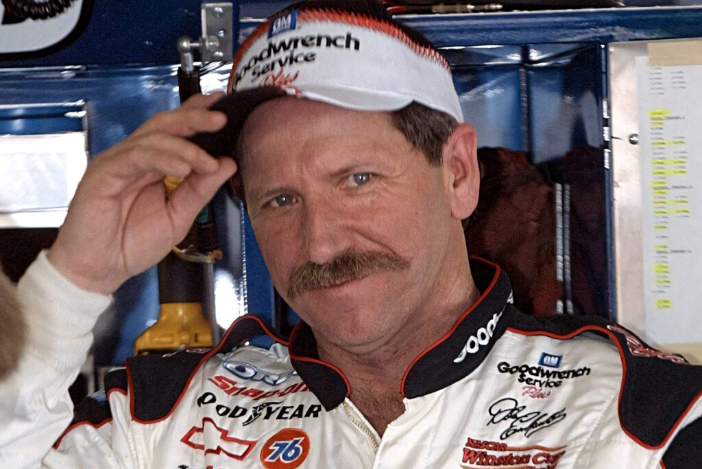 Dale Earnhardt in iconic NASCAR uniform with mustache confident classic motorsports wallpaper background