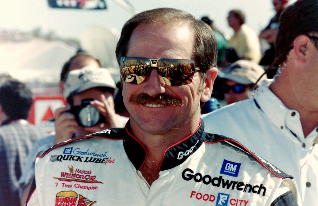Dale Earnhardt in sunglasses and racing suit with mustache vibrant NASCAR wallpaper background