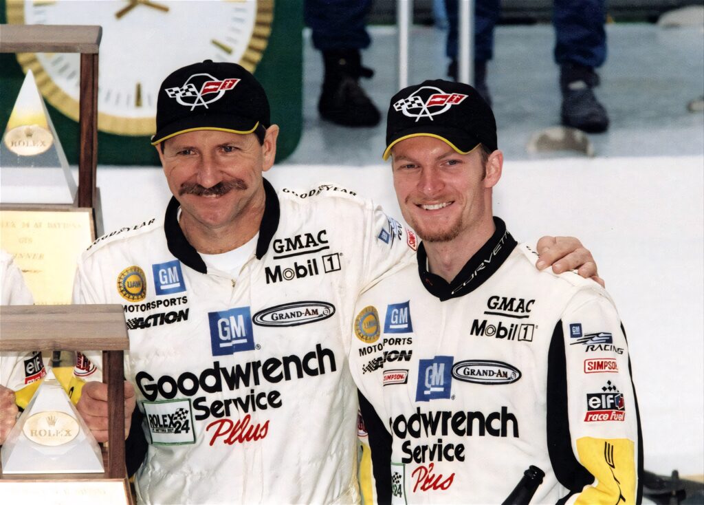 Dale Earnhardt Sr and Jr in racing suits celebrating NASCAR legacy with sponsor logos wallpaper