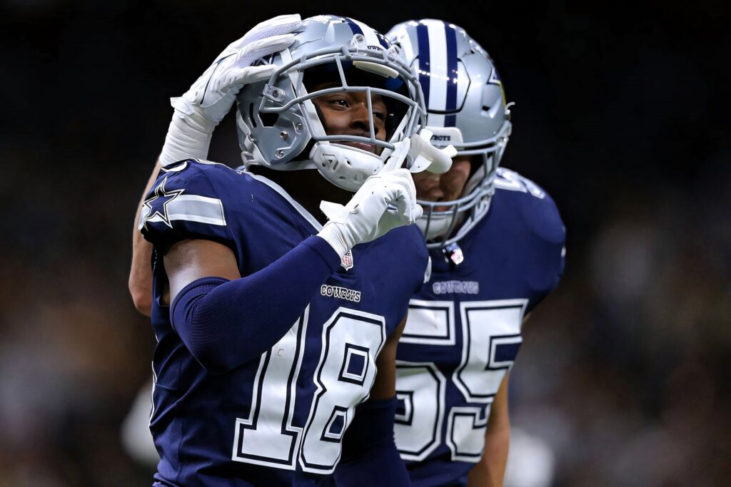 Dallas Cowboys player in navy blue jersey and silver helmet celebrates victory with teammate hug Wallpaper