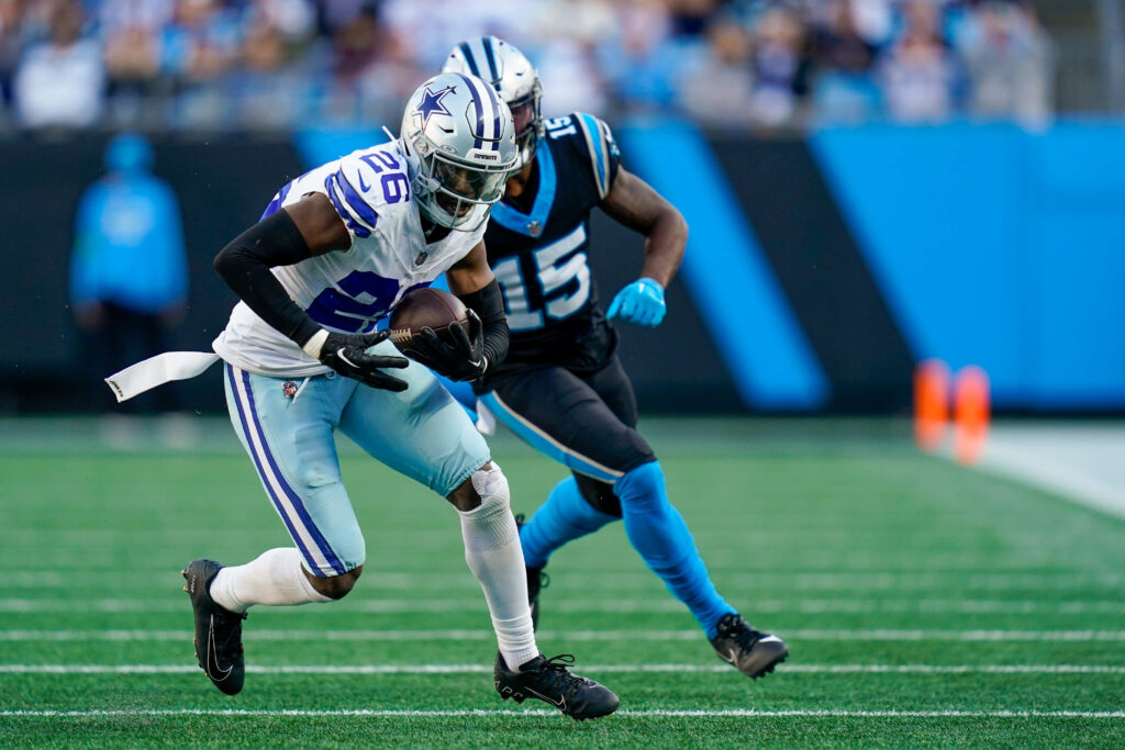 Dallas Cowboys cornerback DaRon Bland intercepts pass against Carolina Panthers on green turf Wallpaper