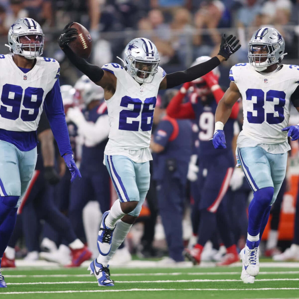 Dallas Cowboys cornerback Daron Bland celebrates a key defensive play with teammates on field Wallpaper