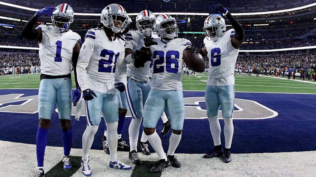 Dallas Cowboys players celebrate touchdown in home stadium with fans and bright lights background Wallpaper