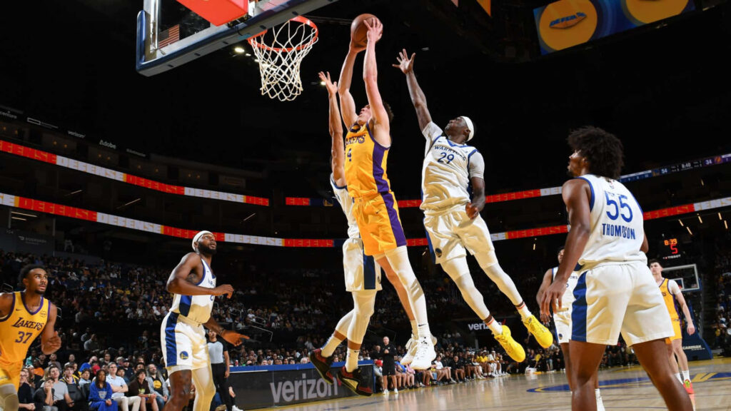 Dalton Knecht leaps toward basket in vibrant gold blue basketball game with intense defense and lighting Wallpaper