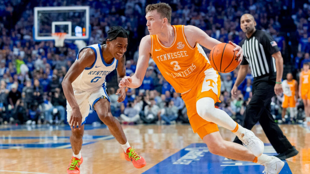 Dalton Knecht dribbles basketball guarded by Rob Dillingham during Tennessee vs Kentucky game at Rupp Arena Wallpaper
