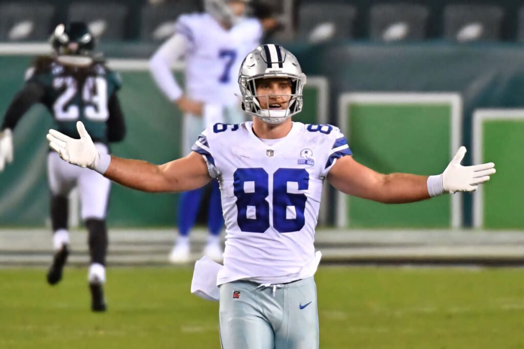 Dalton Schultz Dallas Cowboys in action on vibrant NFL field with arms outstretched game intensity Wallpaper