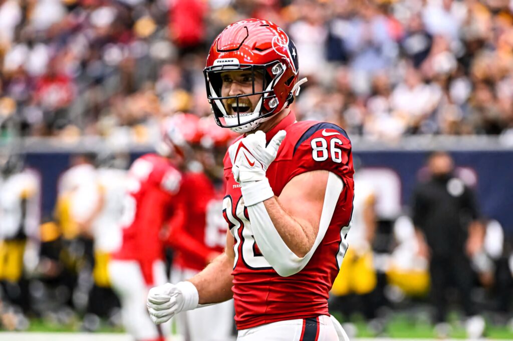 Dalton Schultz number 86 in red football uniform poised on field with vibrant stadium background Wallpaper