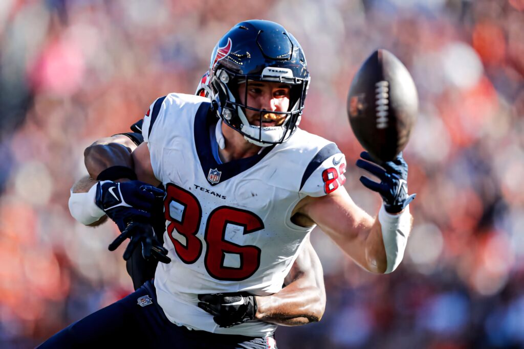 Dalton Schultz Houston Texans jumping mid-air catching football showcasing focus and athleticism wallpaper