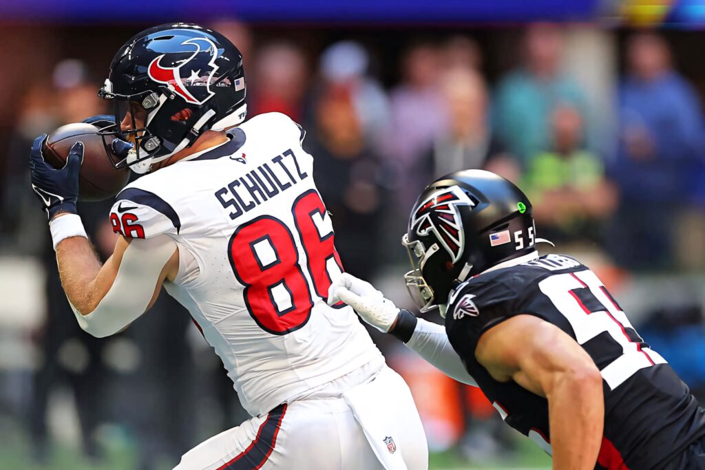 Dalton Schultz catching football in Houston Texans uniform during intense NFL game action Wallpaper