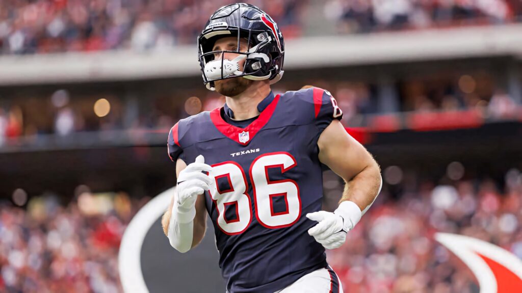 Dalton Schultz number 86 in Houston Texans navy red uniform in dynamic football action shot Wallpaper