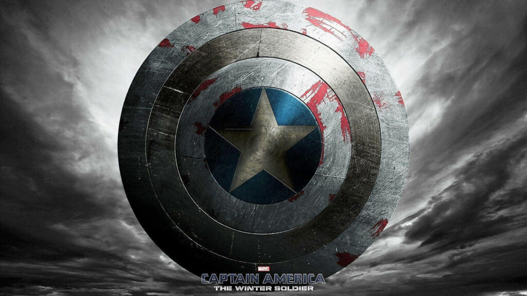 Fading Heroism: Weathered Captain America Shield stands resilient amidst a dramatic cloudy backdrop Wallpaper