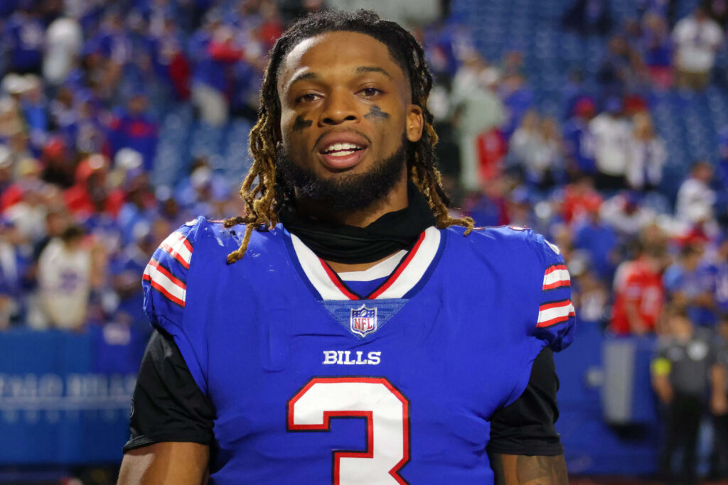 Portrait of Buffalo Bills player Damar Hamlin in blue and red uniform on football field wallpaper