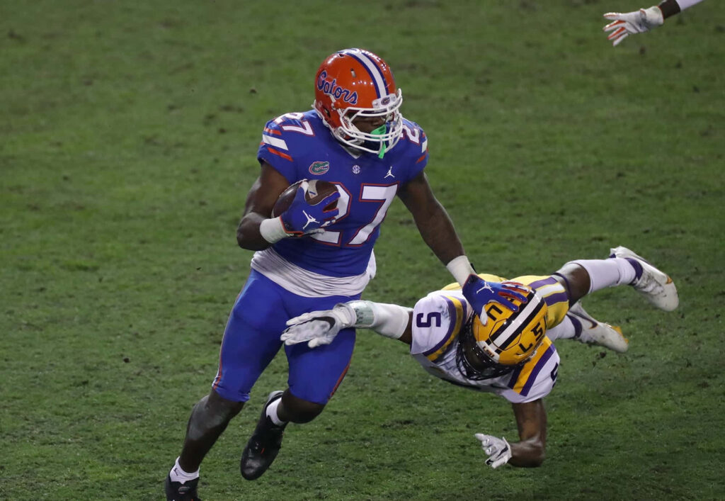 Dameon Pierce in Florida Gators uniform powers forward evading LSU defender in football game Wallpaper