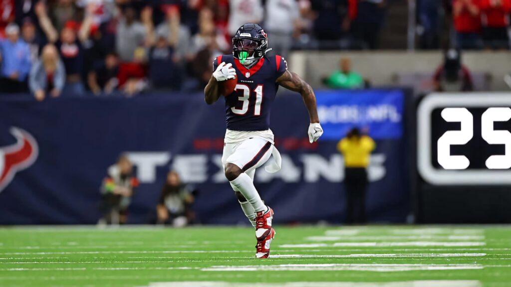 Dameon Pierce running back sprinting on football field vibrant stadium bold team colors wallpaper