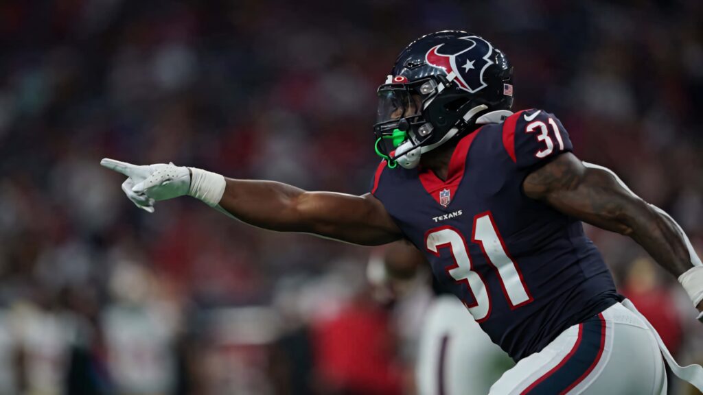 Houston Texans running back Dameon Pierce in navy uniform pointing mid-play on stadium field Wallpaper