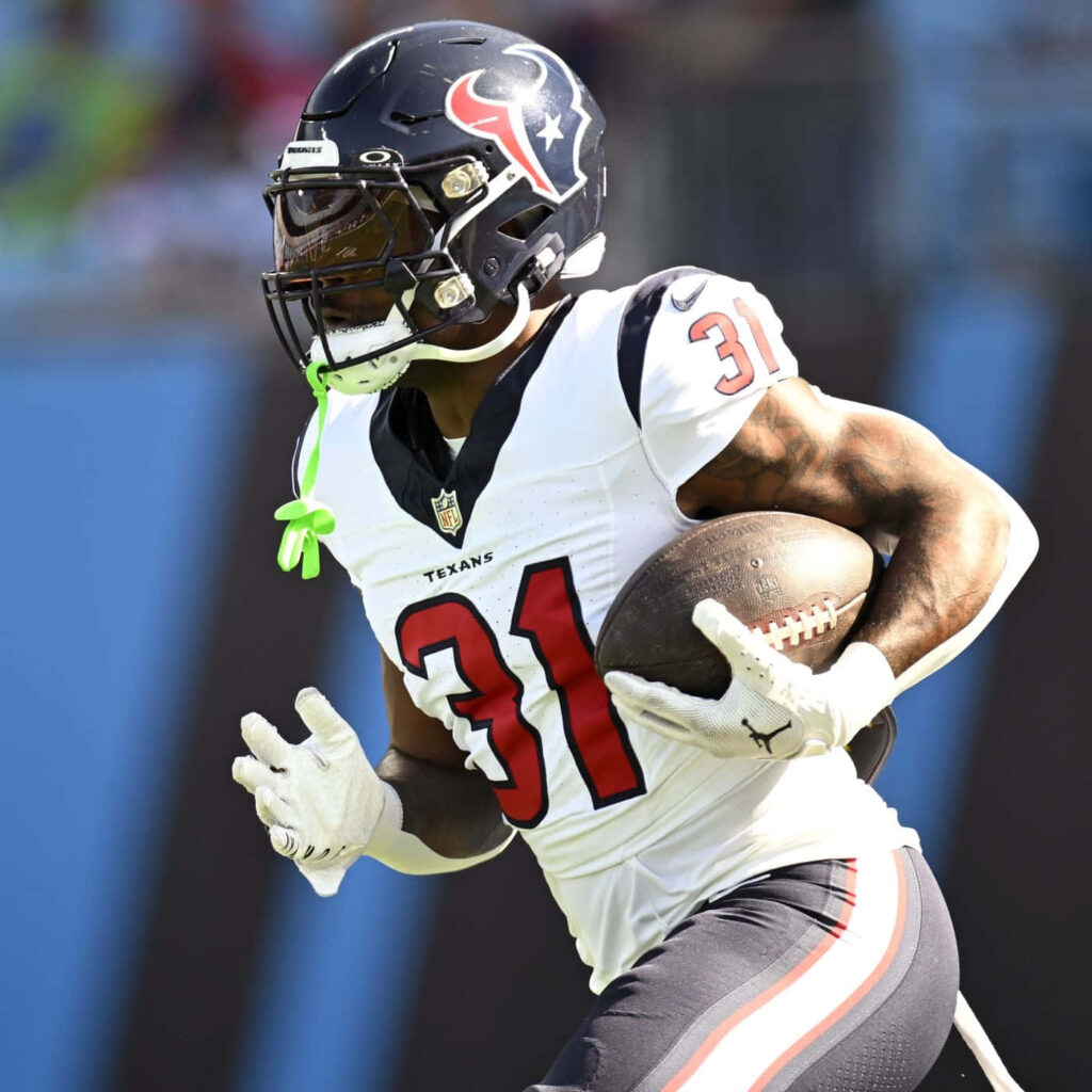 Dameon Pierce Houston Texans running back mid-action in white blue uniform gripping football wallpaper