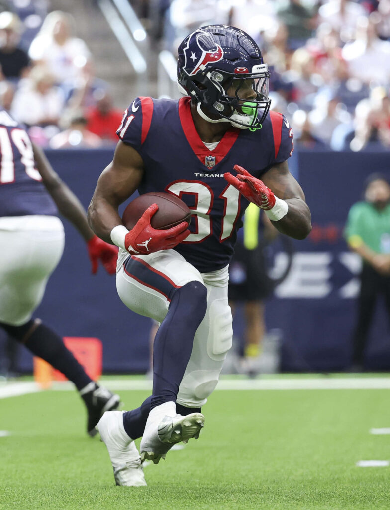 Dameon Pierce Houston Texans running football navy blue red white uniform on green field action Wallpaper