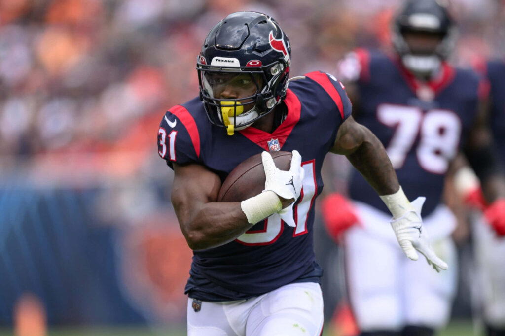 Dameon Pierce Houston Texans running back in action wearing deep blue red uniform dynamic stadium background Wallpaper