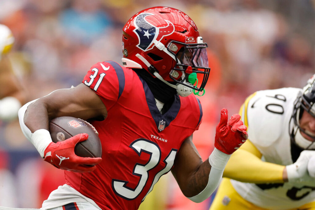 Dameon Pierce Houston Texans running back sparks intense action in red and navy football uniform Wallpaper