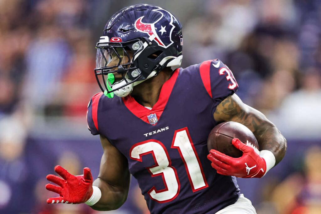 Dameon Pierce Houston Texans running back in navy red uniform sprinting with football on field Wallpaper