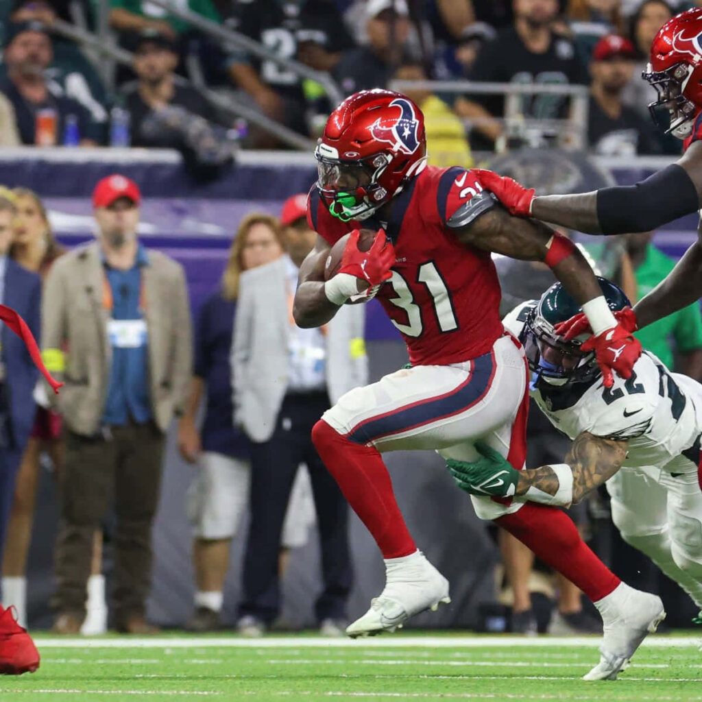 Dameon Pierce Houston Texans running back charging field vibrant red uniform intense football action Wallpaper