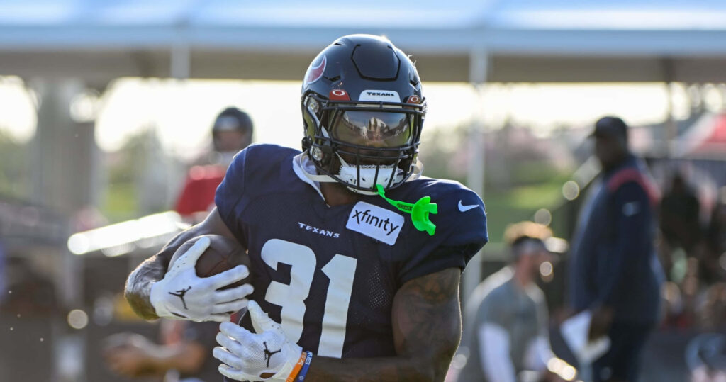 Dameon Pierce Houston Texans running back powering forward in navy red uniform during practice Wallpaper