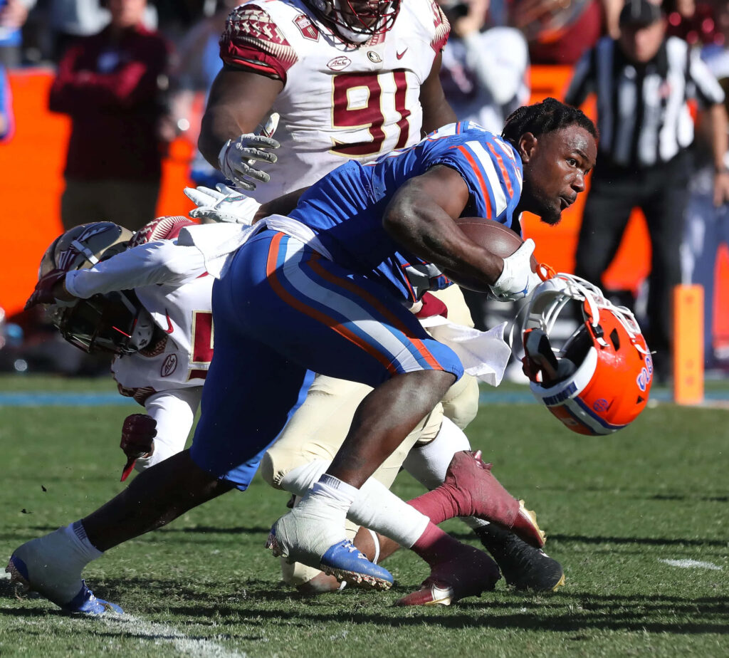 Dameon Pierce breaking tackles in intense football action with vivid team colors and sharp detail Wallpaper