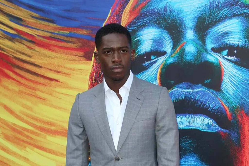 Damson Idris as Franklin Saint in sharp grey suit vibrant abstract colorful artistic backdrop Wallpaper