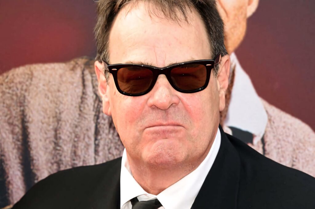 Dan Aykroyd in black suit and sunglasses sharp focus blurred background wallpaper image