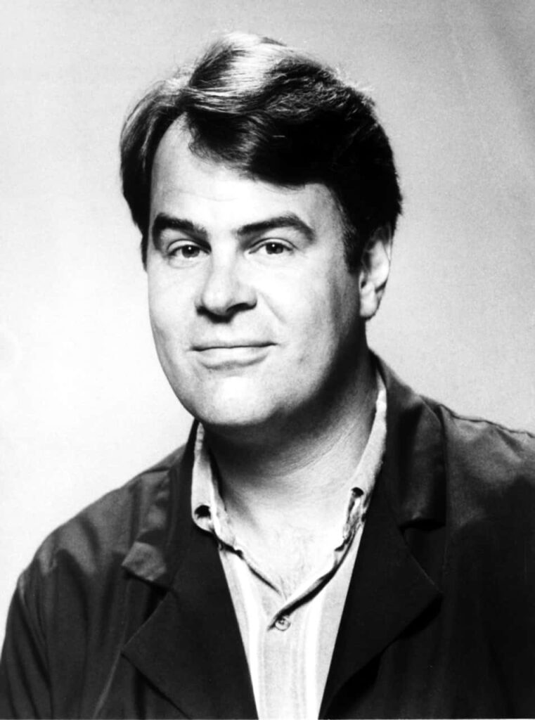 Dan Aykroyd black and white portrait wallpaper with confident smile and soft lighting background