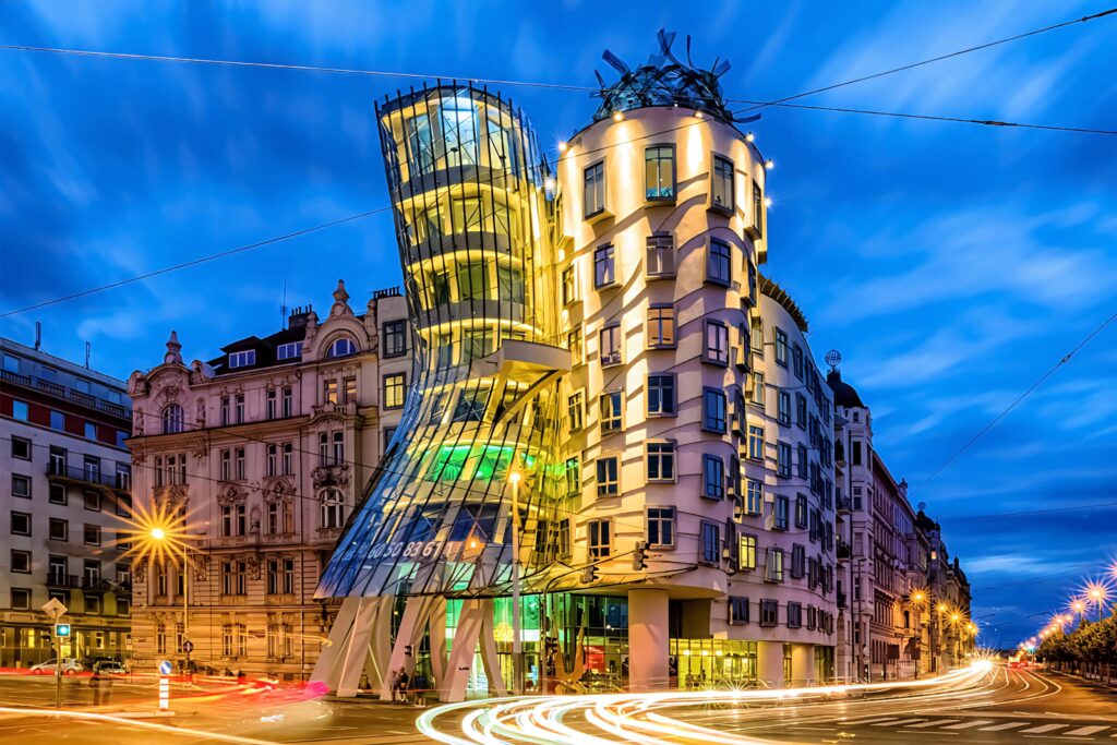 Dancing House Prague glowing at twilight with light trails and modern glass curves urban scene Wallpaper