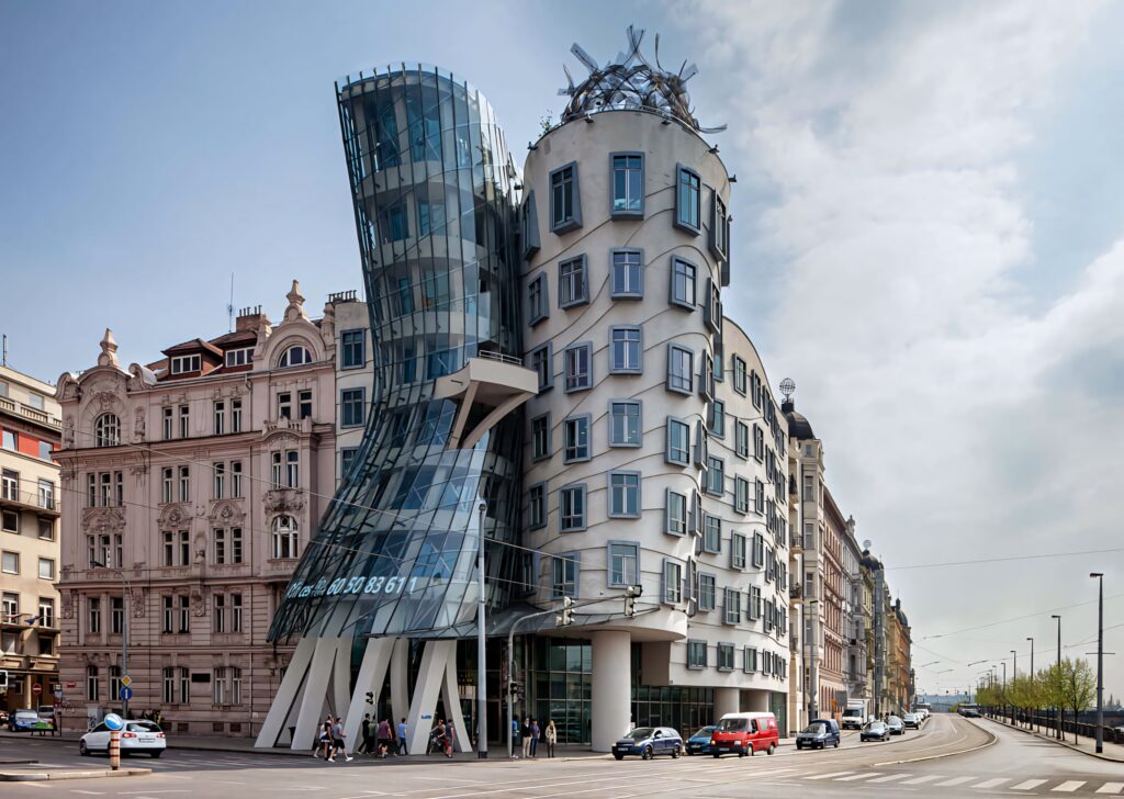 Dancing House Prague wallpaper showing curving glass towers and historic buildings under clouds