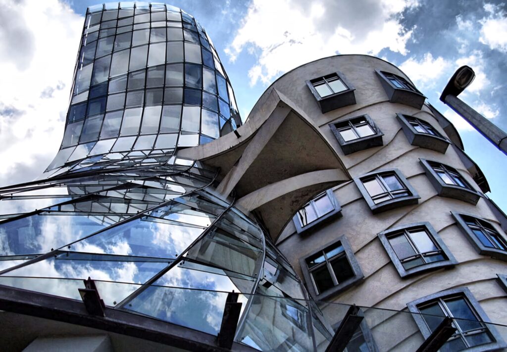 Dancing House Prague modern architecture wallpaper with glass curves and dramatic sky background