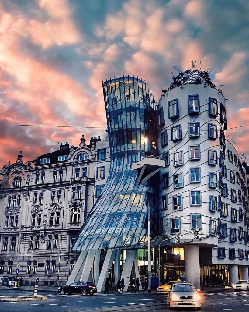 Dancing House Prague deconstructivist architecture with colorful sunset sky and historic buildings Wallpaper