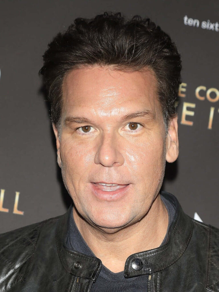 Close-up portrait of comedian Dane Cook with confident expression and dark event background wallpaper
