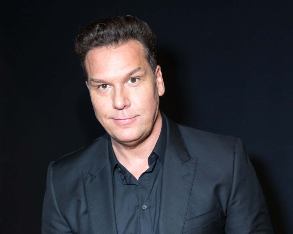Dane Cook in sleek black suit on dark minimalist background confident stylish portrait wallpaper