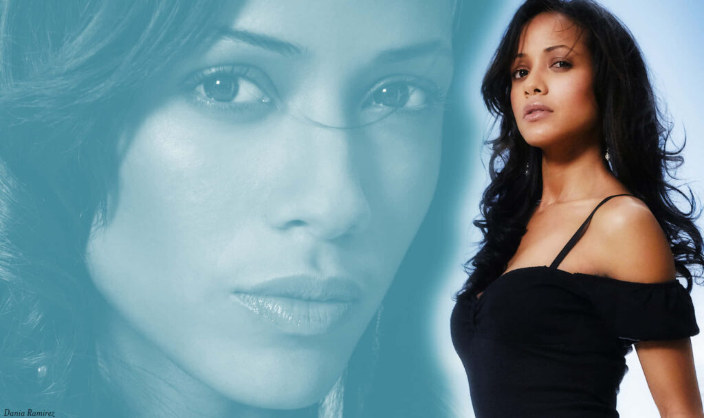 Dania Ramirez in black off-shoulder outfit with soft blue background elegant modern wallpaper