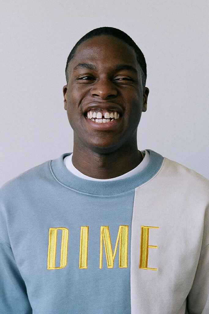Daniel Caesar portrait wallpaper with soft lighting color-blocked DIME sweatshirt neutral background