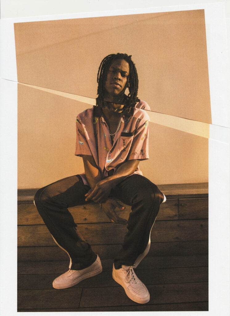 Daniel Caesar portrait sitting on bench warm lighting pastel pink shirt artistic paper tear effect wallpaper