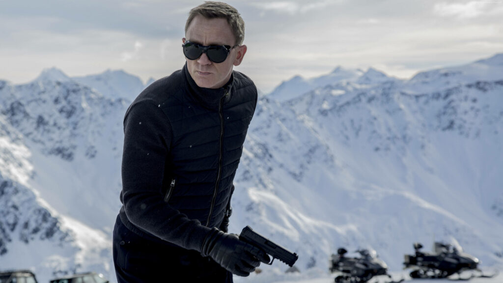 Daniel Craig holding gun in snowy mountain landscape intense action movie scene wallpaper