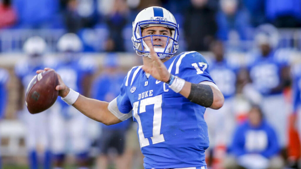 Daniel Jones Duke Blue Devils football player poised to throw vibrant jersey stadium background Wallpaper