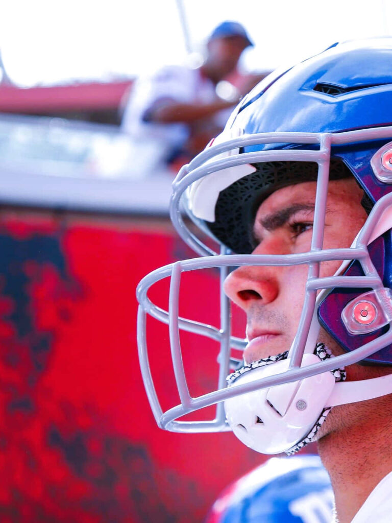 Daniel Jones intense game day portrait in glossy helmet red and blue vibrant sports wallpaper background