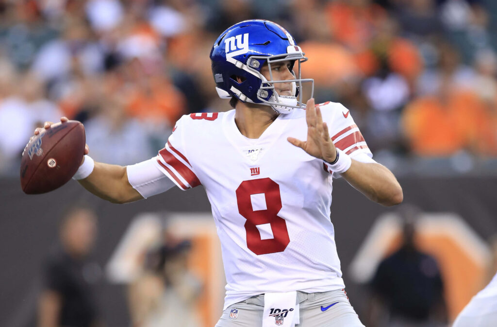 Daniel Jones New York Giants quarterback mid-throw in white blue uniform dynamic stadium action Wallpaper